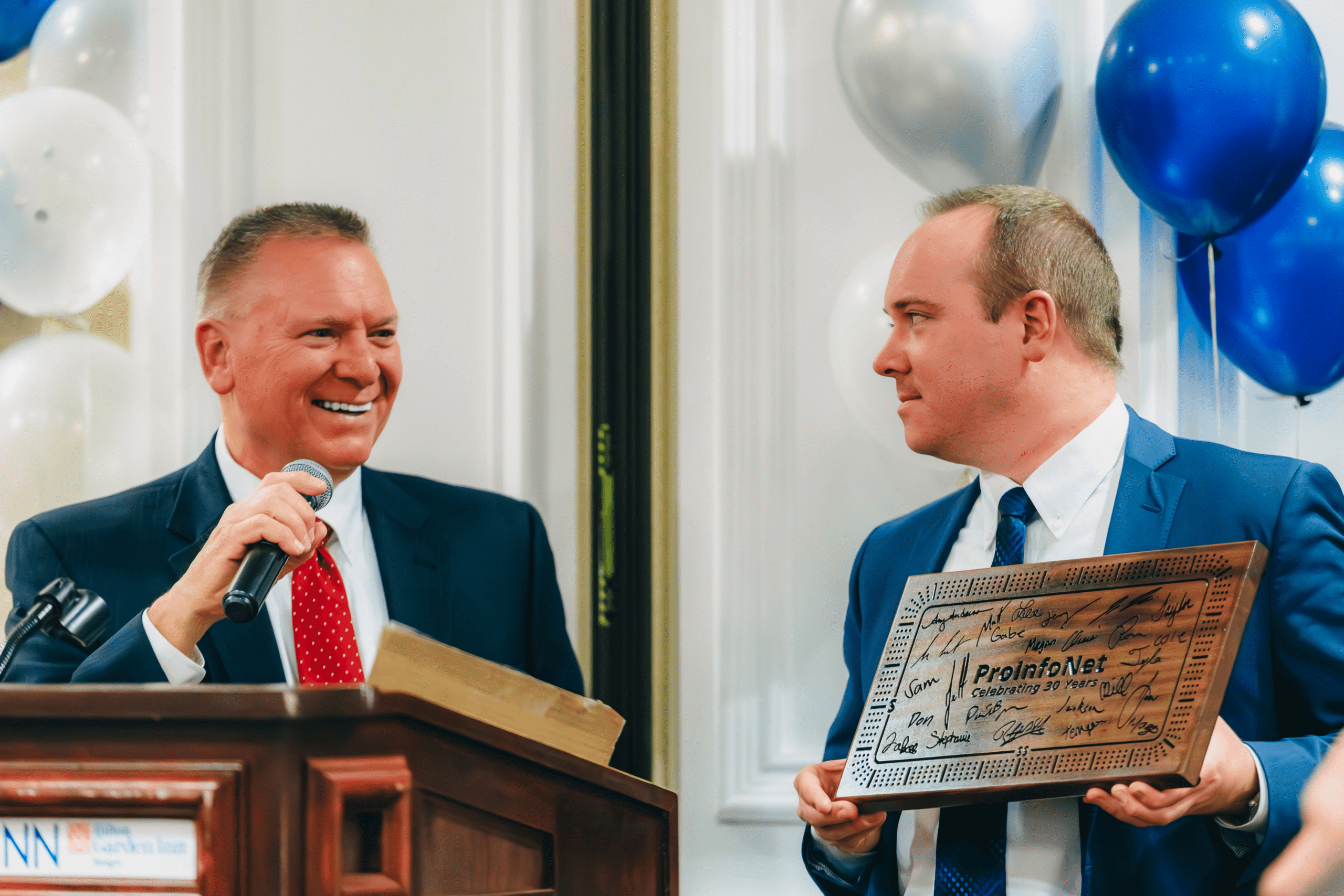 Jim Rogers (President & CEO) and Jeff Rogers (VP of Finance & Operations) speaking at ProInfoNet’s 30th anniversary celebration on December 4, 2025.